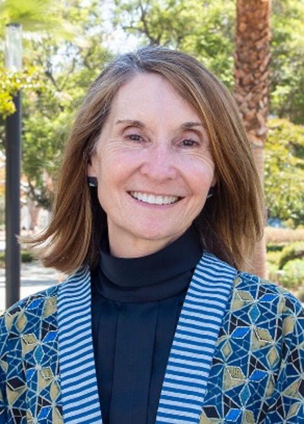 Photo of Sheryl Fontaine smiling in front of flowers