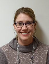 lady with glasses wearing sweater smiling