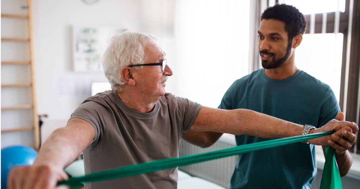 man with nurse exercising with green stretch band