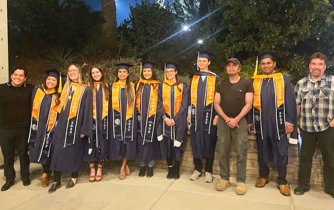 Students smiling while wearing their graduation regalia