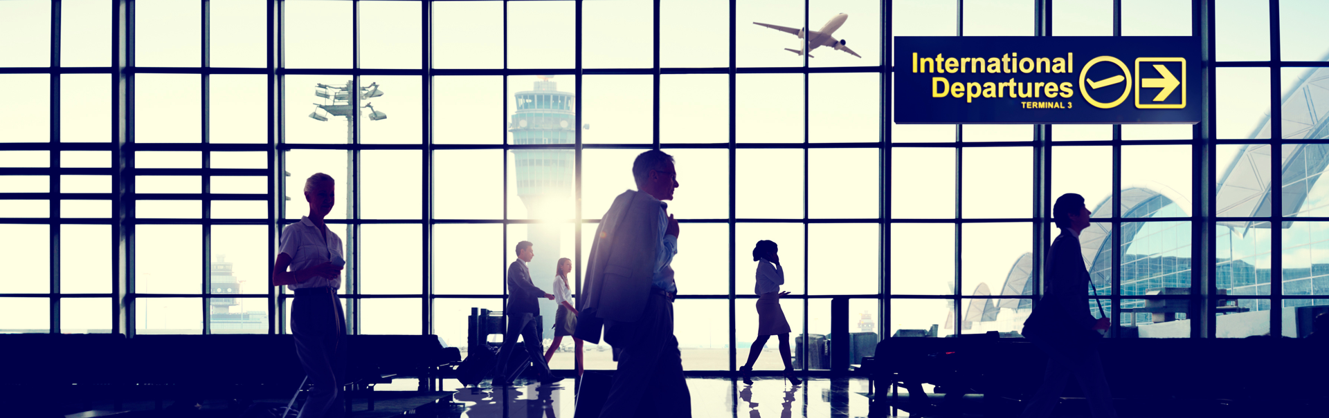 Airport termnial with people walking back and fourth. 